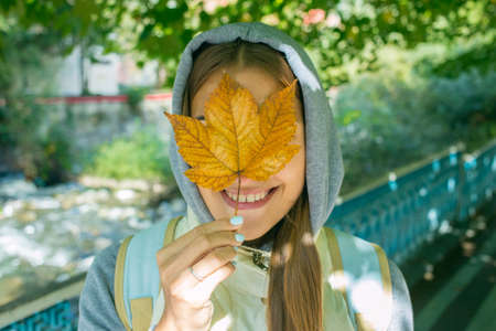Beautiful Autumn Woman with Autumn Leaves on Fall Nature Backgroundの写真素材