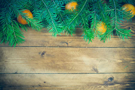 Christmas background with fir tree and decoration on dark wooden board tangerines, fruit, garnet,の写真素材