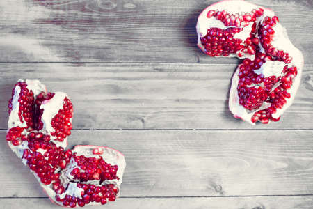 Ripe pomegranate fruits on the wooden background. Top view.の写真素材