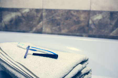 Blurred bathroom interior background and white spa towels on Marble Bathtub Mirror Faucet Toothbrush razorの写真素材