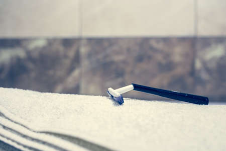 Blurred bathroom interior background and white spa towels on Marble Bathtub Mirror Faucet Toothbrush razorの写真素材