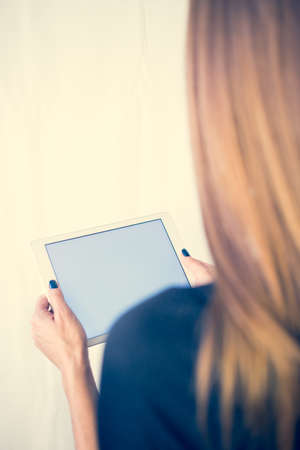 Girl on a tablet computer, browses the information. The white background and the screen.