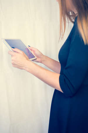 Girl on a tablet computer, browses the information. The white background and the screen.の写真素材