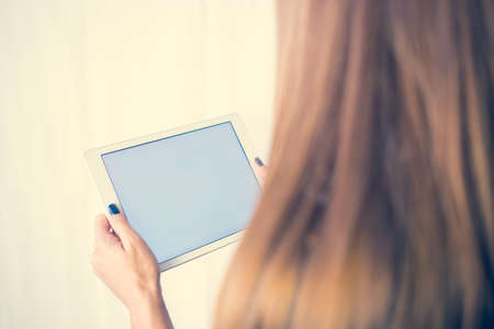 Girl on a tablet computer, browses the information. The white background and the screen.の写真素材