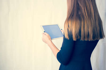 Girl on a tablet computer, browses the information. The white background and the screen.の写真素材