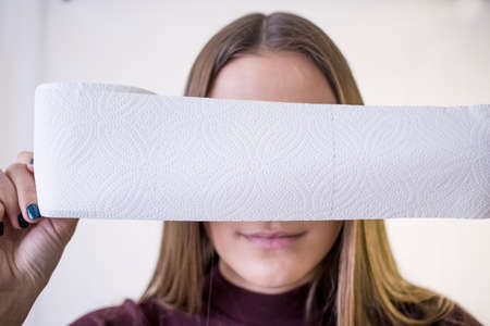 woman take toilet paper. covers the face.の写真素材