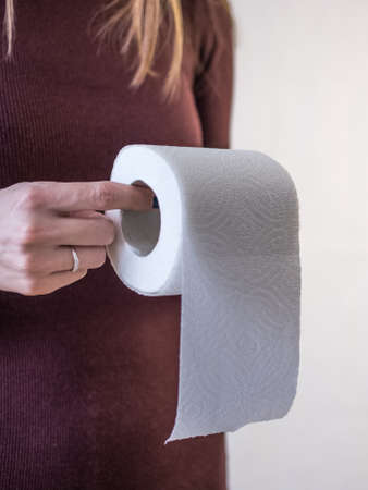 woman take toilet paper. Burgundy dress and white background.の写真素材