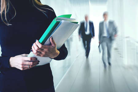 Young business woman with folder in the office building. Office going people.の写真素材