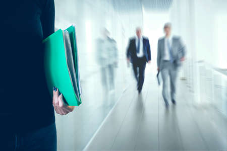 Young business woman with folder in the office building. Office going people.の写真素材