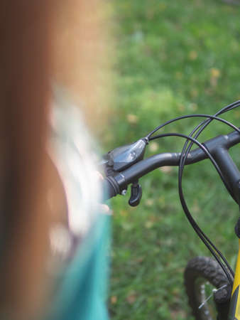 Young slender woman standing by bicycle and looking to a sky. Girl holding a Bicycle handlebar. bike