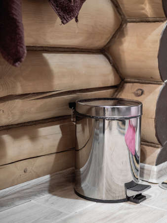 Toilet paper holder with rolls and trash bin in bathroom interior. wood logs backgroundの写真素材