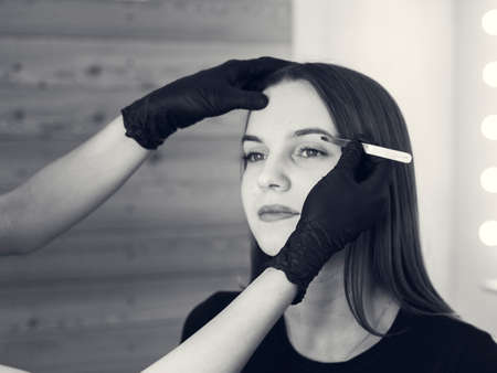 Artistic design of eyebrows. Correction. Pin forceps Woman having her eye brows tinted....