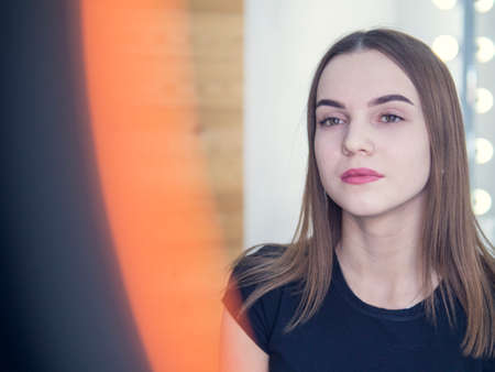 Make-up artist combing eyebrow on model's face.