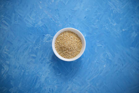 Quinoa is an organic food for healthy eating. In a round bowl. The blue background is painted with oil paintsの写真素材