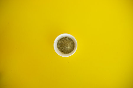 Top view of organic matcha green tea in a bowl and matcha powder. Yellow cheerful backgroundの写真素材