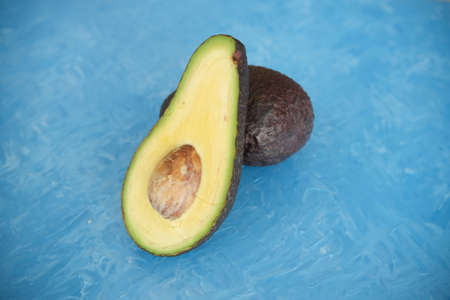 avocado on a background of blue butter texture. selective focus. Half of it. Healthy foodの写真素材