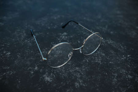 Silver metal glasses. On a solid black stone background. With a soft blurred electoral background. Eyepieces, Vision. top view.の写真素材