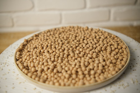 Raw chickpeas, rotation. Chickpeas, close-up. In a plate on a wooden table. Selective focus.の写真素材