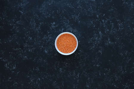 Red lentils close-up. Background with lots of lentils. Minimalism. Black background. Top view. Soft focus.の写真素材