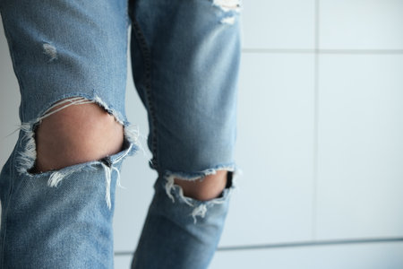 close-up of a man in torn jeans. Blue, old, fashionable, shabby. On a white background. Italian fashionの写真素材