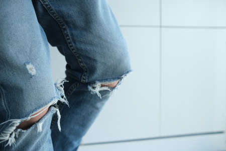 close-up of a man in torn jeans. Blue, old, fashionable, shabby. On a white background. Italian fashionの写真素材