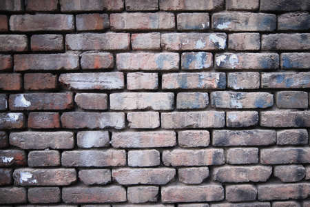 Background of old vintage dirty brick wall with peeling plaster, texture.の写真素材