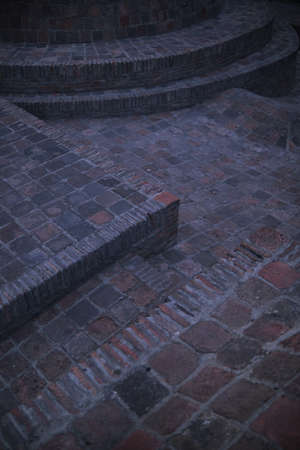 Vintage red brick wall. Empty background of brown brickwork. Sturdy brickwork textured rough surface. Two types of masonry. Corner.の写真素材
