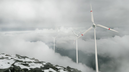 Wind turbines on a mountain pass, renewable energy. Clouds are floating, a hazy haze. snow. The concept of renewable energy sources. wind turbines in winterの写真素材