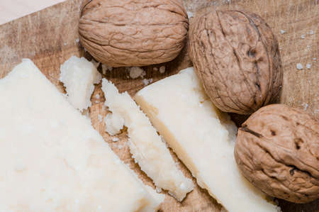 nuts and parmesan cheese on a cutting boardの写真素材