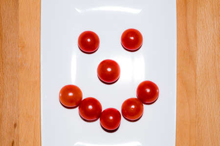 tomato-shaped smile on white dishの写真素材