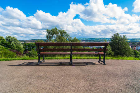 Bench in a park view from behind: the background blue skyの写真素材