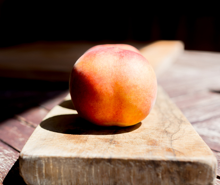 Close-up of a peach on a cutting boardの写真素材