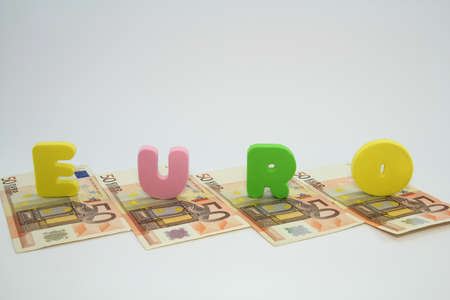 Four fifty euro banknotes under the colorful word euro on white background の写真素材
