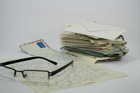 Spectacles and old letters isolated on white background の写真素材