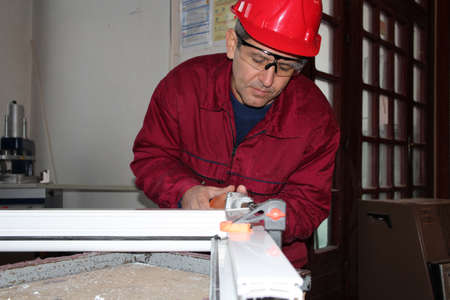 Manufacturing worker at work whit small electric grinder in workshop の写真素材