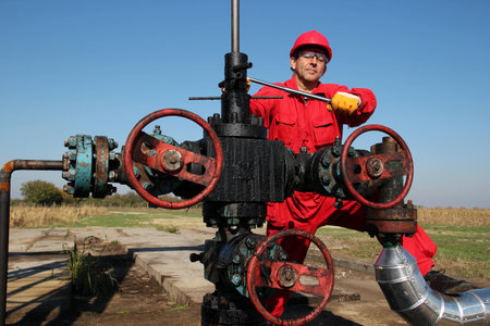 Oil Industry Worker repairing a oil pumping unit at a oil field の写真素材