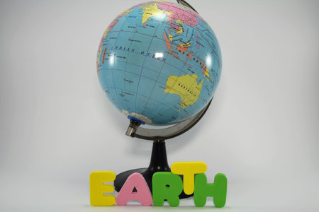 Colorful letters in front of earth globe spelling the word earth on white background の写真素材