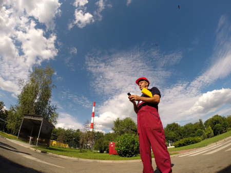 Industrial worker standing in factory premises and looking at cell phone.の写真素材