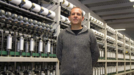 Portrait of an engineer in front of automated machines for Yarn manufacturing.の写真素材