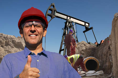 Group of oil field workers in action at oil wellの写真素材