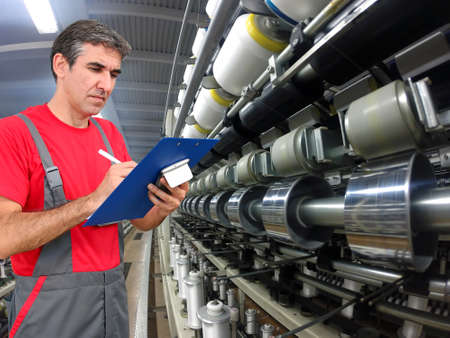 Quality control inspector using clipboard and writing in modern textile mill