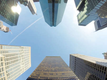 Wide angle photo looking up with tall skyscrapers of the city of Manhattan on a sunny dayの写真素材