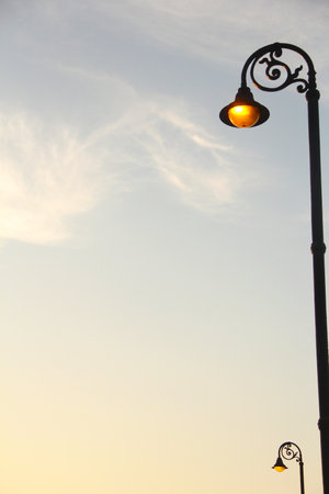 Spotlight at sunset on a light blue sky with some clouds. Abstract urban image. The focus is...