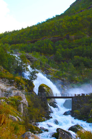 A waterfall with white water between the mountains. Ideal if you like to travel to exotic places and you are a lover of waterfalls, lakes and glaciers.の写真素材
