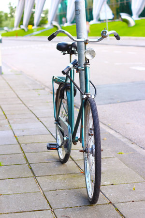 Colorful bicycle, parked on the public road next to a window surrounded by vegetation, Image of tranquility in the street.の写真素材
