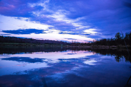 Beautiful sunset on the lake with clouds reflected in the water.の写真素材