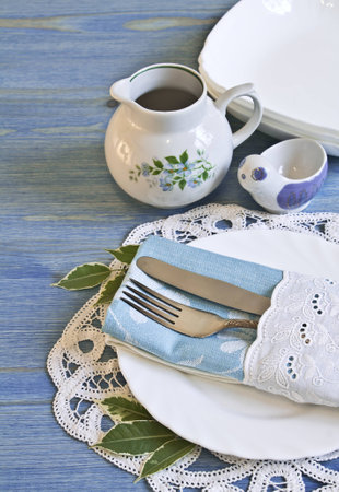 Vintage table setting with leaves decorations, napkins on a blue wooden board backgroundの写真素材