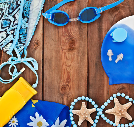 goggles, shells, swimsuit on a wooden background  set for the beachの写真素材