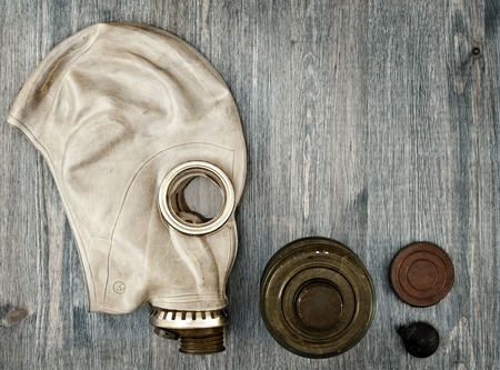 Old gas mask and additional accessories on wooden backgroundの写真素材