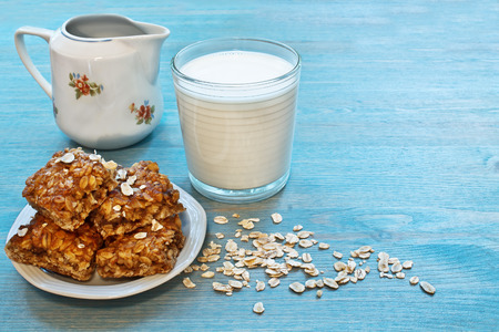 oat snacks, a glass of milk on a blue wooden tableの写真素材